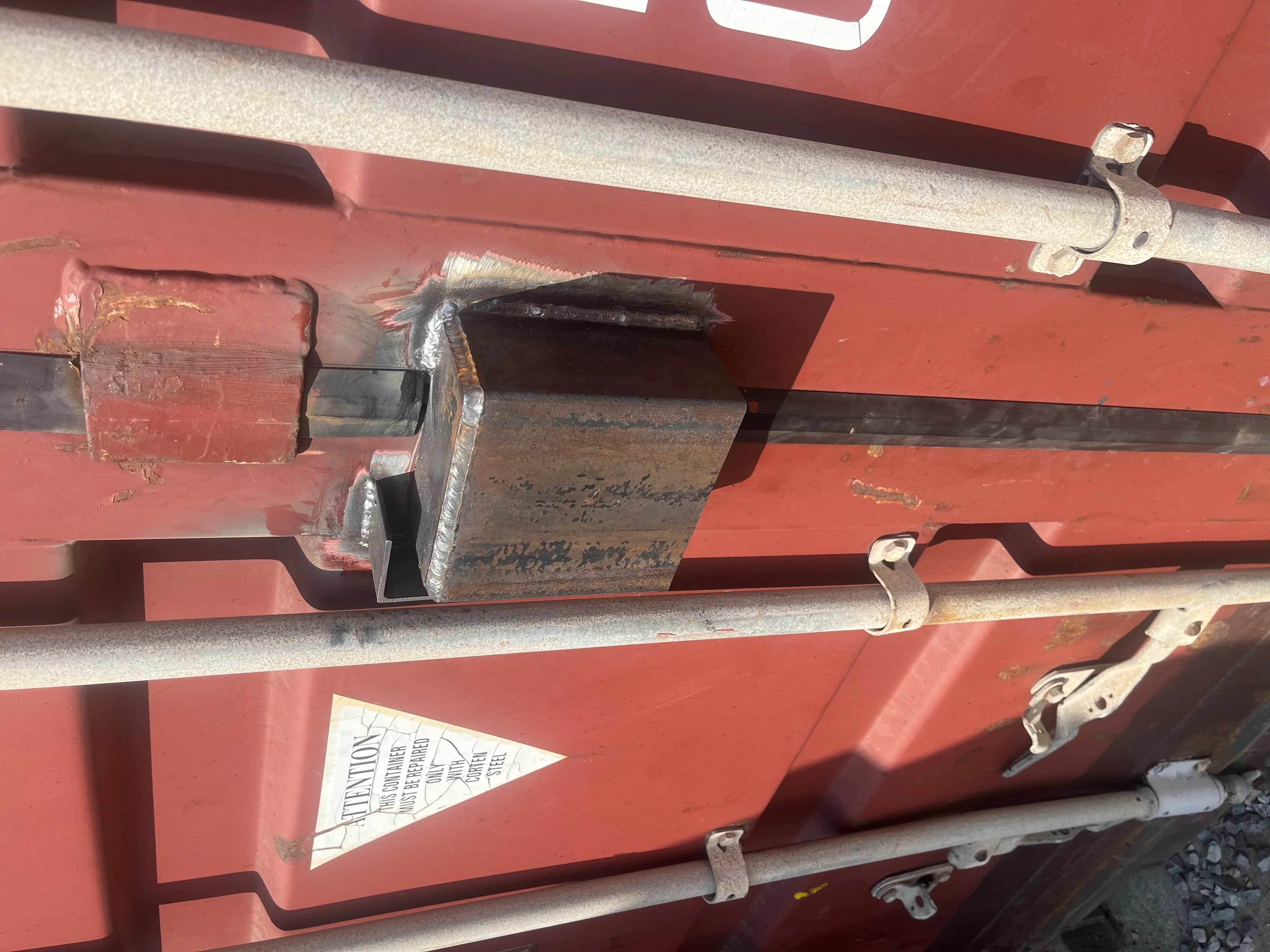 Welded steel hitch bracket assembly on red trailer frame with galvanized fasteners