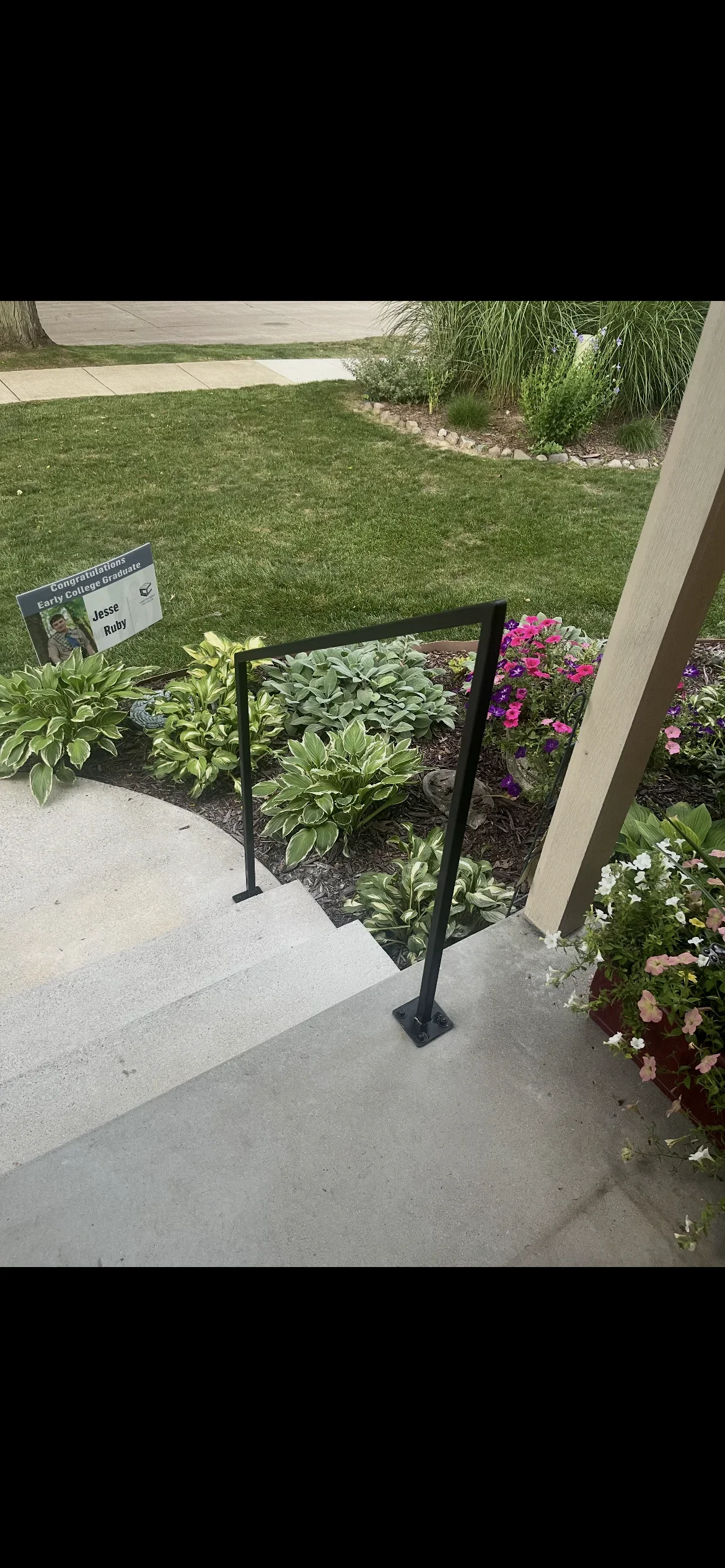 Black steel welded railing with square tubing and base plate at residential entry